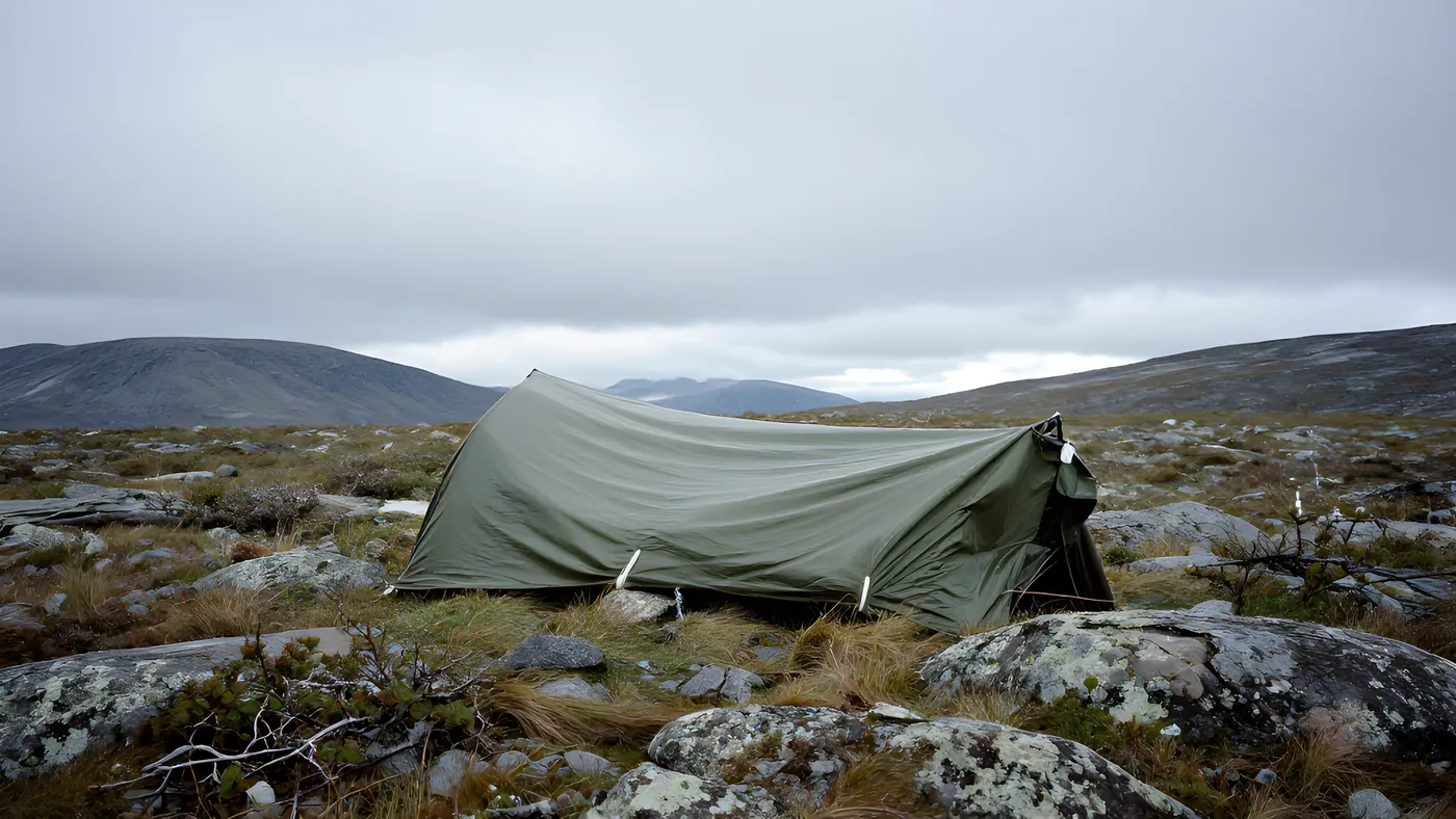En tarp uppspänd i öppen fjällterräng ovan trädgränsen, utan skydd av träd eller terräng.